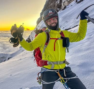 Parker Wolf on a mountain summit at sunset
